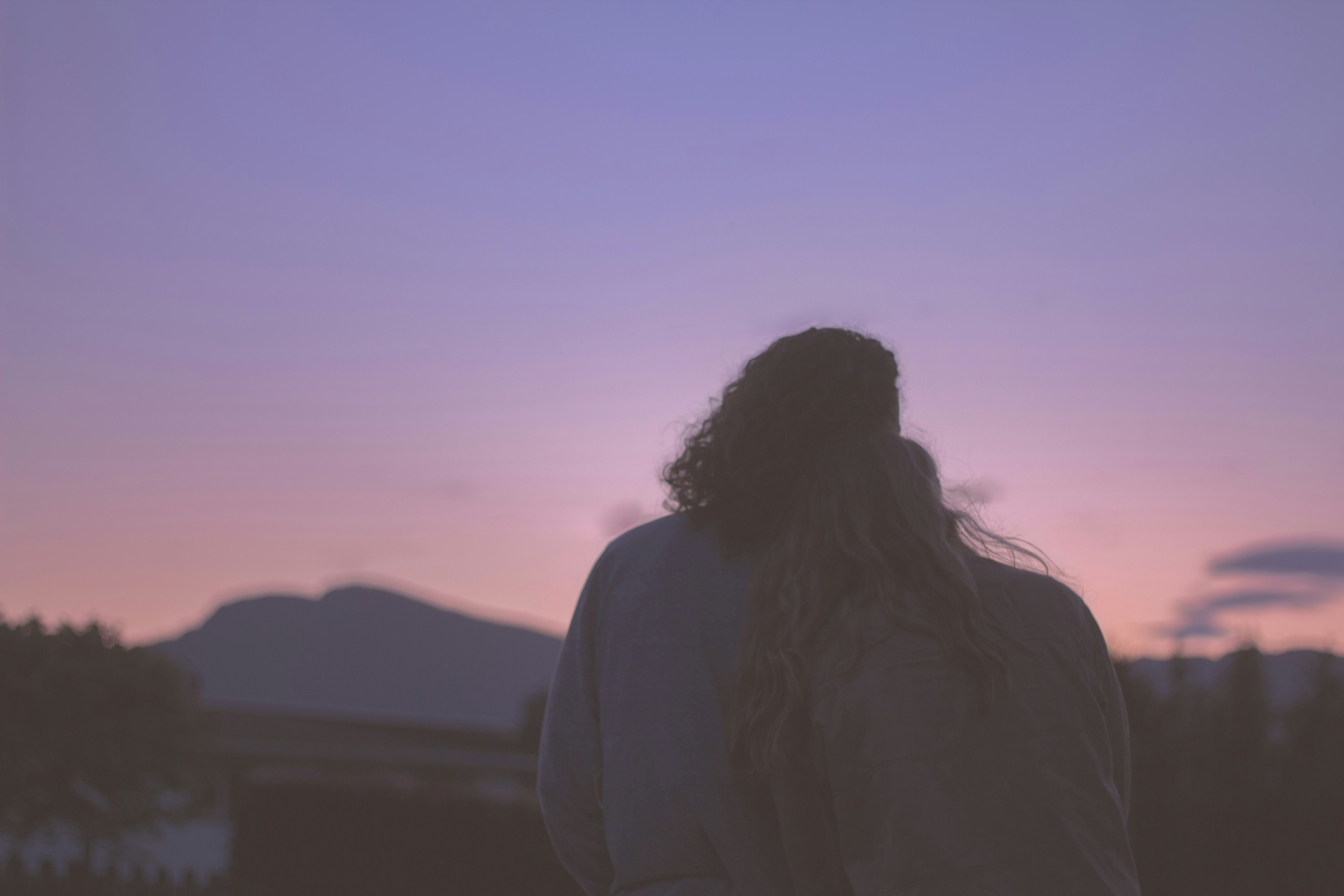 silhouette of woman standing during sunset